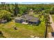 Aerial view of a beautiful landscaped backyard with an outdoor deck, playground, and mature trees at 16805 Tobacco Rd, Lutz, FL 33558