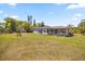 Expansive backyard featuring a covered deck, lush lawn, and playset at 16805 Tobacco Rd, Lutz, FL 33558