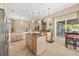 Open kitchen area featuring an island cooktop, granite counters, and seamless flow to the outdoor dining area at 16805 Tobacco Rd, Lutz, FL 33558