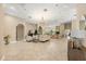 Open-concept living room with high ceilings, travertine floors, and an archway to the kitchen at 16805 Tobacco Rd, Lutz, FL 33558