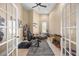 Bright home office with neutral tones, high ceilings, French doors, ceiling fan, and multiple work areas at 16805 Tobacco Rd, Lutz, FL 33558