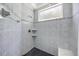 Walk-in shower featuring neutral tiling, a showerhead, and shelving at 16805 Tobacco Rd, Lutz, FL 33558