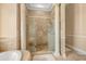 Close up of a detailed walk-in shower, featuring marble tile walls, a glass door, and decorative pillars at 16805 Tobacco Rd, Lutz, FL 33558