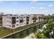 Exterior view of condo building near water featuring balconies and palm trees in a waterfront community at 2486 Caring Way # 17A, Port Charlotte, FL 33952