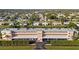 Exterior full view of tan condo building with parking underneath and trimmed hedges in a community at 2486 Caring Way # 17A, Port Charlotte, FL 33952