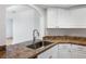 Kitchen featuring granite countertops, stainless steel sink, and white cabinetry at 2486 Caring Way # 17A, Port Charlotte, FL 33952
