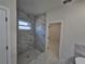 Bright bathroom features a shower with marble tile surround and natural light from the window at 3105 Lockwood St, Port Charlotte, FL 33952