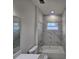 Bright bathroom features a tub with marble tile surround and natural light from the window at 3105 Lockwood St, Port Charlotte, FL 33952