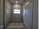 Bright bathroom features a tub with marble tile surround and natural light from the window at 3105 Lockwood St, Port Charlotte, FL 33952