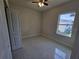 Bright bedroom with tile floors, ceiling fan, and natural light from the window at 3105 Lockwood St, Port Charlotte, FL 33952