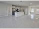 Bright, open-concept living room with tile floors that flow into the kitchen and dining area at 3105 Lockwood St, Port Charlotte, FL 33952