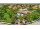 A beautiful aerial view of a community clubhouse, a pool, and well maintained lawns and trees at 4062 Overture Cir # 4062, Bradenton, FL 34209