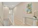 Upstairs hallway featuring tile floors, neutral walls, and a decorative table with palm tree art at 4062 Overture Cir # 4062, Bradenton, FL 34209