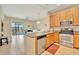Open-concept kitchen showcasing wood cabinets and stainless steel appliances with balcony view in background at 4062 Overture Cir # 4062, Bradenton, FL 34209