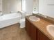 Bright bathroom featuring a dual sink vanity, soaking tub, and tiled floors for a clean and modern feel at 11510 Southern Creek Dr, Gibsonton, FL 33534