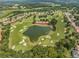 Expansive golf course view with scenic pond, tree coverage, and residential houses in a well-maintained community at 12387 Eastpointe Dr, Dade City, FL 33525