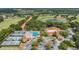 Community aerial showcasing a pristine pool, tennis courts, golf course, lake, and elegant clubhouse at 12387 Eastpointe Dr, Dade City, FL 33525