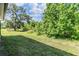 Beautifully landscaped backyard with mature trees and lush green grass provides a serene and private outdoor space at 12387 Eastpointe Dr, Dade City, FL 33525