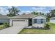 Charming single-story home with a well-manicured lawn and blue shutters, showcasing its inviting curb appeal at 12387 Eastpointe Dr, Dade City, FL 33525