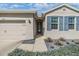 Charming single-story home with blue shutters, a beige garage door and meticulously landscaped front yard at 12387 Eastpointe Dr, Dade City, FL 33525