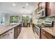 Modern kitchen featuring granite countertops, stainless steel appliances, and dark wood cabinetry at 12387 Eastpointe Dr, Dade City, FL 33525