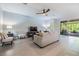 Well-lit living room with neutral tones, tile floors, and a view of the screened-in patio at 12387 Eastpointe Dr, Dade City, FL 33525