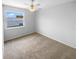 Cozy bedroom with a ceiling fan, neutral carpet, and a window providing natural light and outside view at 1857 Clearbrooke Dr, Clearwater, FL 33760