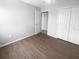 Spacious bedroom with wood-look flooring, a ceiling fan, a closet, and a view into another room at 1857 Clearbrooke Dr, Clearwater, FL 33760