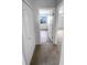 Carpeted hallway with views of a closet and bedroom with wood-look flooring and natural light at 1857 Clearbrooke Dr, Clearwater, FL 33760
