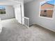 A carpeted upstairs landing featuring a staircase, two windows, and a view to the outside at 1857 Clearbrooke Dr, Clearwater, FL 33760