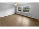 Bright living room featuring modern flooring, a ceiling fan, and lots of natural light from two windows at 1857 Clearbrooke Dr, Clearwater, FL 33760