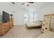 Cozy bedroom with wood floors, a ceiling fan, and a view of the ensuite bathroom at 13405 Fawn Springs Dr, Tampa, FL 33626