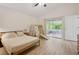 Bright bedroom with wood floors, ensuite bath, ceiling fan, and sliding doors to an outdoor patio at 13405 Fawn Springs Dr, Tampa, FL 33626