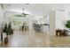Open-concept living room with tile floors, fan, large windows, breakfast bar, and connecting kitchen at 13405 Fawn Springs Dr, Tampa, FL 33626