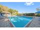 Community pool surrounded by lounge chairs with clear blue skies at 13405 Fawn Springs Dr, Tampa, FL 33626