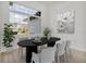 Modern dining room with a black table, six chairs, a plant, and a large window providing natural light at 2551 Alhaven Ter, North Port, FL 34286
