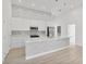 Bright kitchen featuring white cabinets, decorative backsplash and an island with decorative paneling and bar seating at 2551 Alhaven Ter, North Port, FL 34286