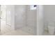 Modern bathroom features an all-tile shower, white toilet, tile flooring, and access to the bedroom at 2551 Alhaven Ter, North Port, FL 34286