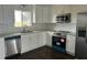 Modern kitchen featuring white cabinets, granite countertops, stainless steel appliances and hardwood flooring at 702 Desert Hills Way, Sun City Center, FL 33573
