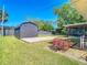 Well-maintained backyard featuring a modern shed, complemented by a vibrant flower bed at 1481 Newton St, Port Charlotte, FL 33952