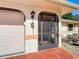 Close-up of the front door with a security screen, decorative accents, and a well-manicured garden at 1481 Newton St, Port Charlotte, FL 33952