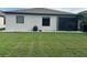 A view of the back of the house with an expansive green lawn at 2137 Apian Way, Port Charlotte, FL 33953