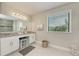 Bathroom features a granite countertop vanity, white cabinets, and a large window with blinds at 2137 Apian Way, Port Charlotte, FL 33953