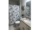 Full bathroom with granite countertop, white cabinets, and a butterfly-themed shower curtain at 2137 Apian Way, Port Charlotte, FL 33953