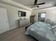 This main bedroom features a tray ceiling, ceiling fan, and a view into the ensuite bathroom at 2137 Apian Way, Port Charlotte, FL 33953