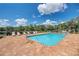Sparkling community pool with lounge chairs, brick paver deck, and trees at 2137 Apian Way, Port Charlotte, FL 33953