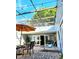 Cozy patio with outdoor dining set, lounge chair, and string lights for evening ambiance at 2806 W Shelton Ave, Tampa, FL 33611