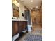 Rustic bathroom featuring a wooden vanity and a decorative tiled shower and neutral-colored design elements at 2806 W Shelton Ave, Tampa, FL 33611