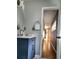 Elegant bathroom with a blue vanity, modern fixtures, and a view into a hallway at 2806 W Shelton Ave, Tampa, FL 33611