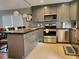 Bright kitchen featuring stainless steel appliances, gray cabinets, tile floors, decorative backsplash, and an island at 2806 W Shelton Ave, Tampa, FL 33611